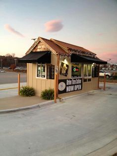 a small building with an awning on the roof that says hot dog now open