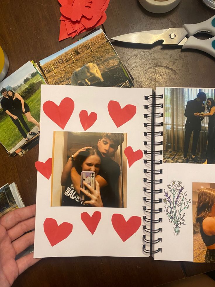 an open notebook with photos and hearts on it