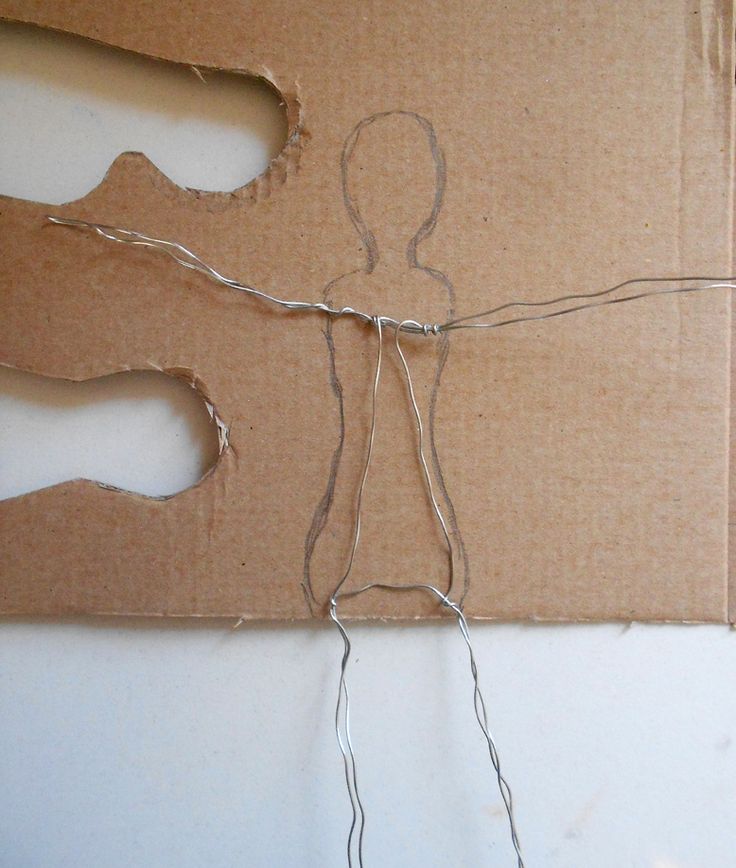 a cardboard cut out of a human being tied up to string with scissors and thread