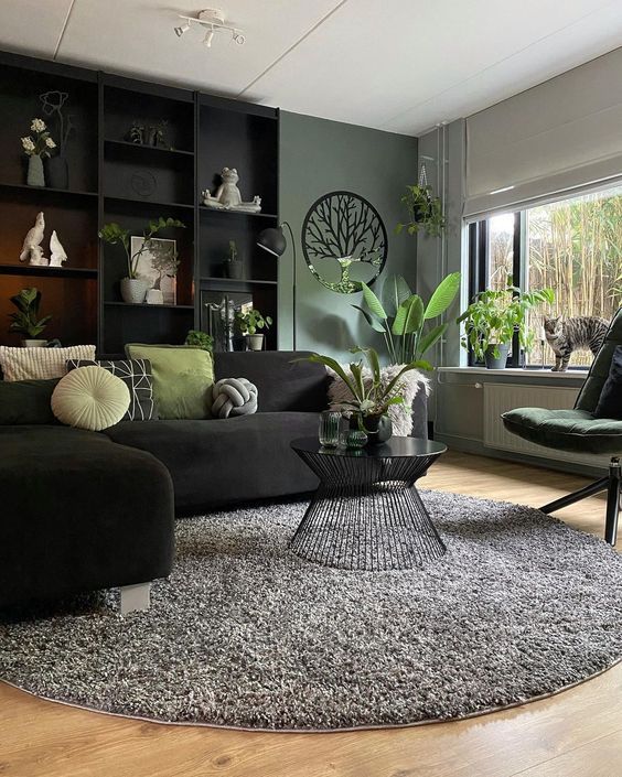 a living room filled with furniture and lots of plants on top of a wooden floor