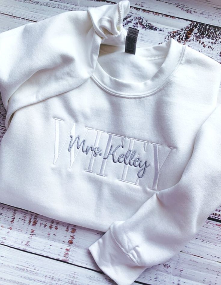 Wifey Sweatshirt-Wife Sweatshirt-Engagement Gift-Wedding Gift-Future Mrs Sweatshirt-Mrs Sweatshirt-Bride Sweatshirt-Embroidered Sweatshirt-Custom Embroidered Sweatshirt-Wife Sweatshirt-Wedding Gift for Her Custom Wifey Sweatshirt Embroidered with your choice of FUTURE, BRIDE, WIFEY or WIFE. This unisex sized custom sweatshirt is super soft and makes an elegant Wifey sweatshirt for you to wear or a wonderful engagement gift for any Wifey or Future Mrs! Perfect for a Bachelorette Party or to wear Fitted White Sweatshirt For Fall, White Winter Top With Embroidered Text, White Fitted Cotton Sweatshirt, White Embroidered Text Top For Winter, White Embroidered Top For Winter, White Long Sleeve Sweatshirt With Letter Embroidery, White Crew Neck Sweatshirt With Letter Embroidery, Fitted Long Sleeve Embroidered T-shirt, White Long Sleeve Top With Custom Embroidery