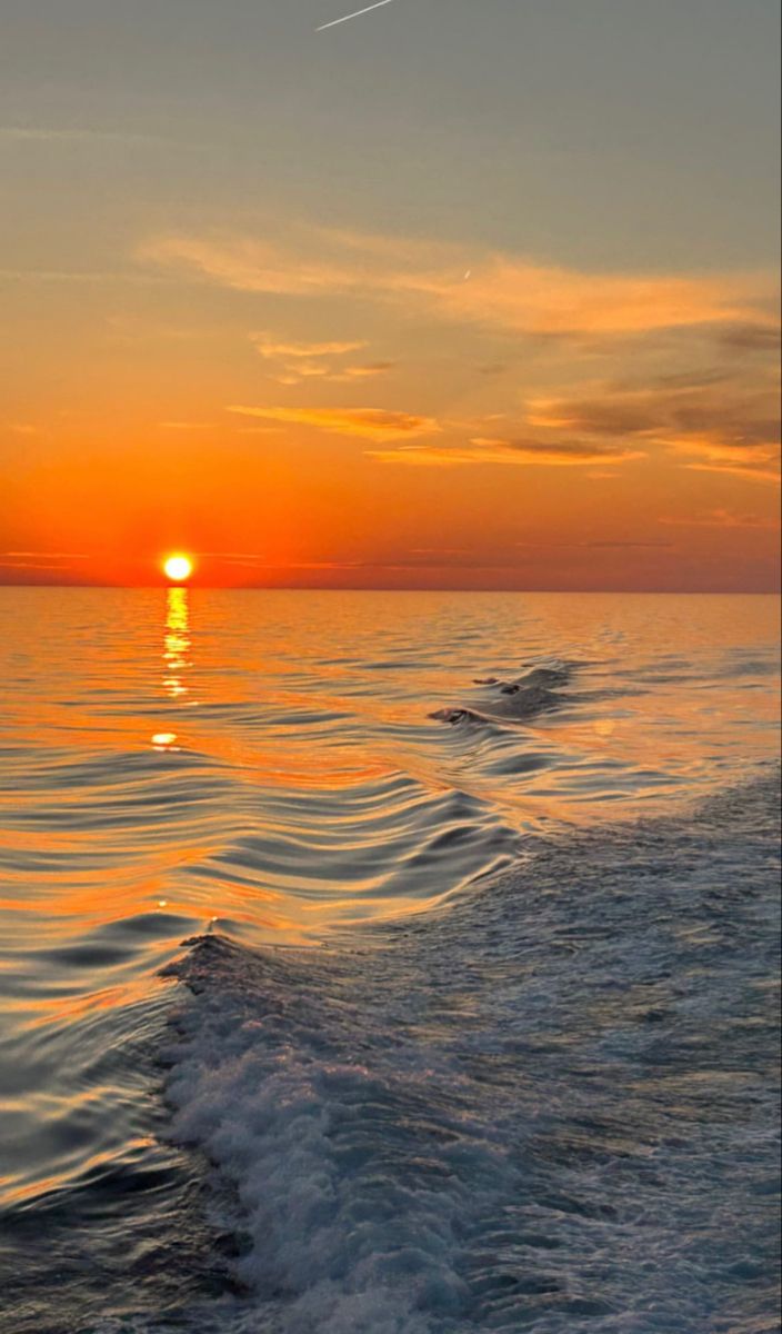 the sun is setting over the ocean with waves