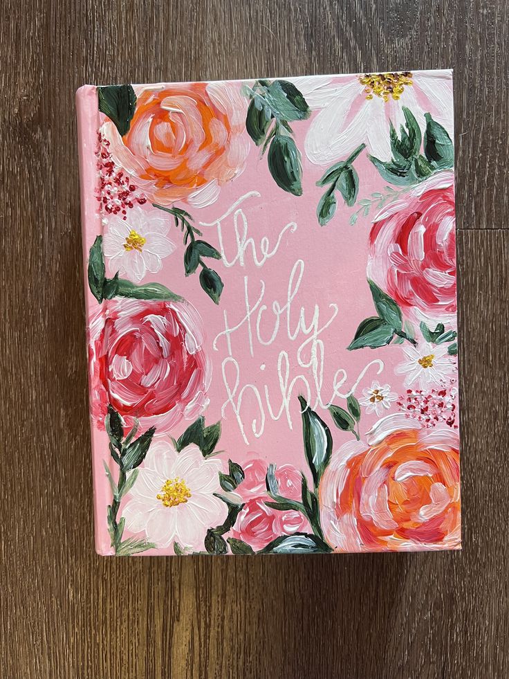 a pink notebook with flowers painted on it