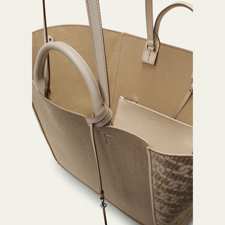 Tod's shopping tote bag in linen and faux leather (polyurethane) Rolled top handles with logo tag  Shoulder straps  Open top Interior, leashed zip pouch bag  Approx. 12.2"H x 27.5"W x 5.5"D Made in Italy Designer Canvas Bag With Double Handle For Errands, Designer Double Handle Canvas Bag For Errands, Beige Double Handle Bag With Dust Bag, Beige Double Handle Bags With Dust Bag, Designer Canvas Tote Bag With Top Carry Handle, Designer Canvas Tote Bag With Top Handle, Tan Coated Canvas Shoulder Bag, Designer Canvas Bag With Removable Pouch For Shopping, Designer Canvas Tote Bag With Removable Pouch