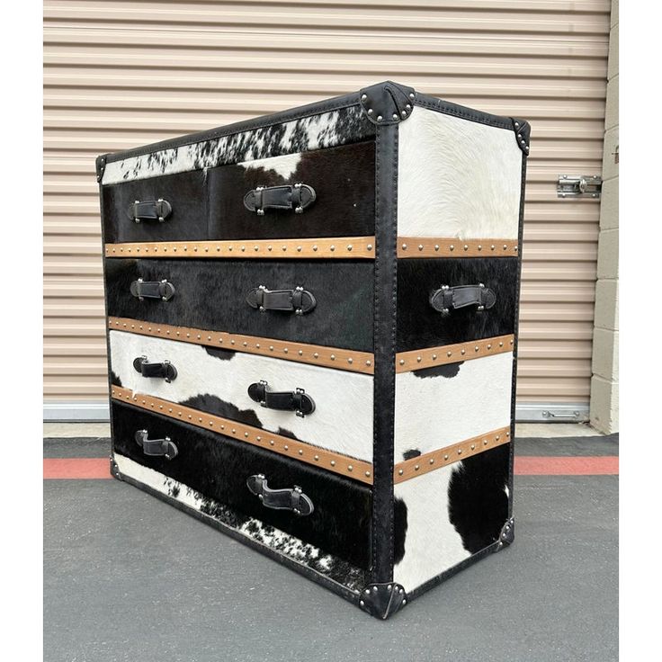 a black and white dresser sitting on top of a parking lot next to a building