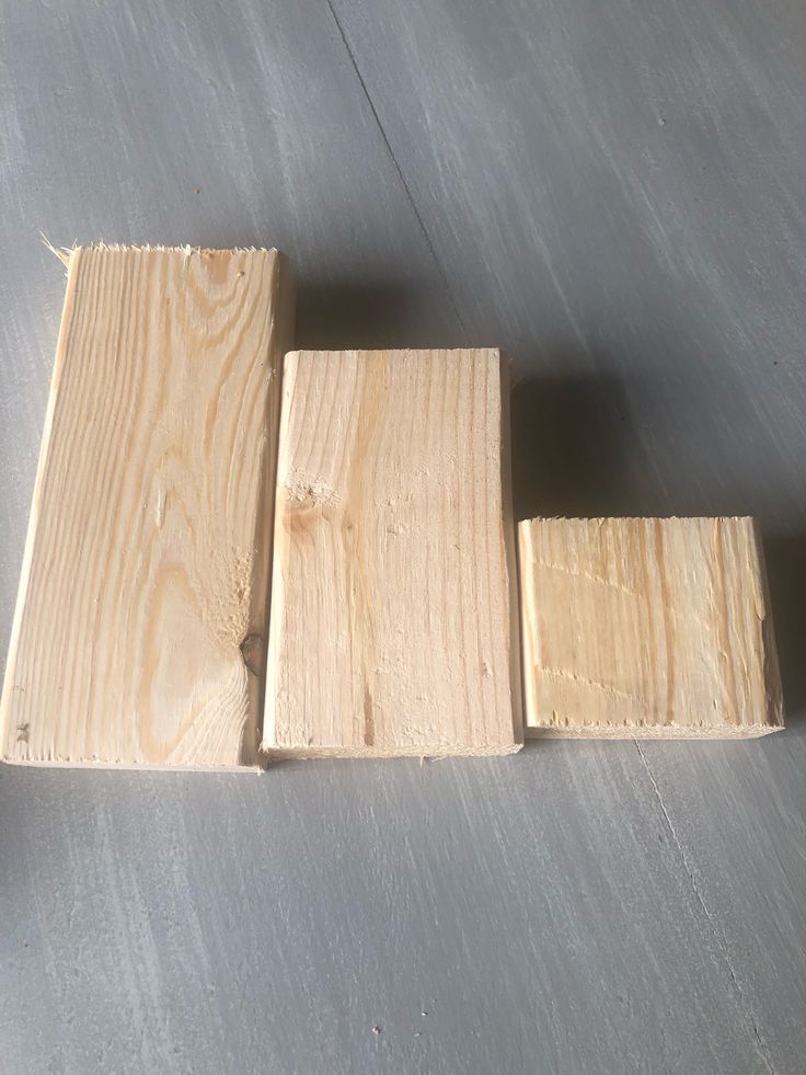 three pieces of wood sitting on top of a metal floor next to each other with one piece missing