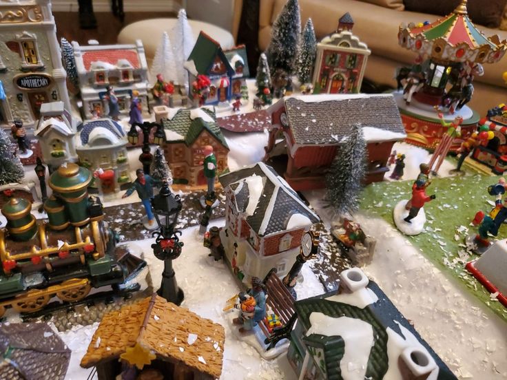 a table topped with lots of different types of christmas decorations and figurines on top of snow covered ground