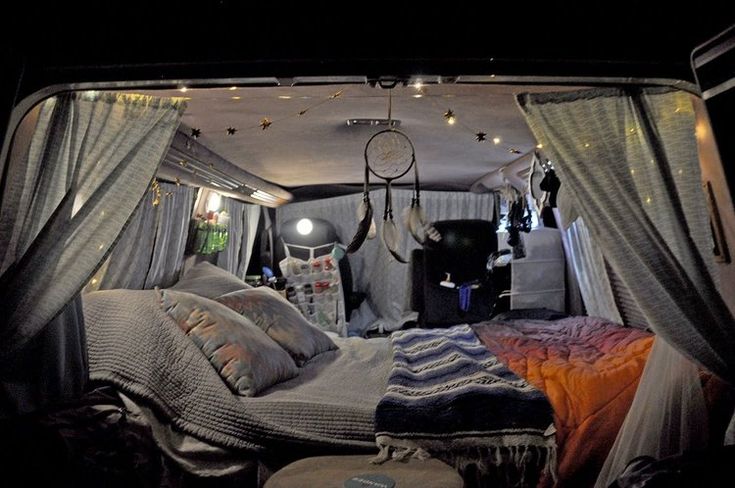 the inside of a camper van with curtains and lights on it's ceiling