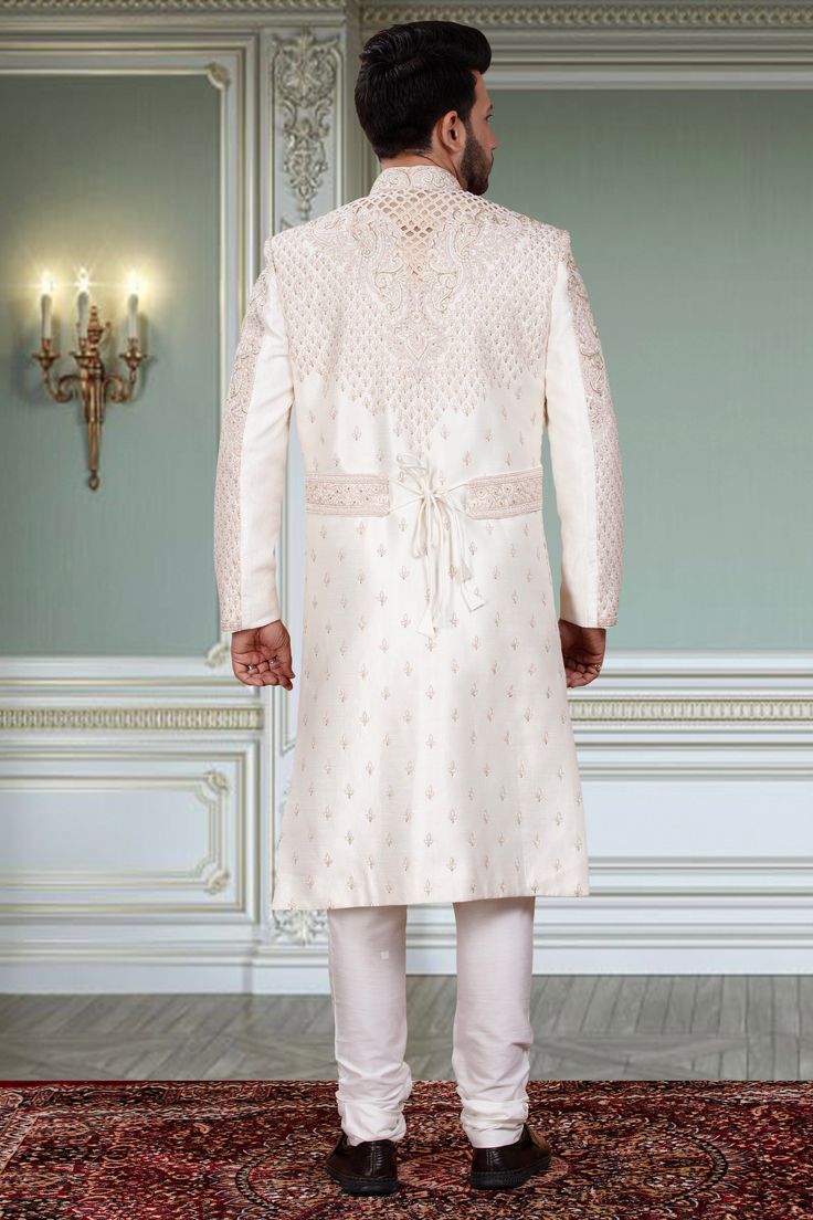 Expertly crafted, this Mens Sherwani- R14-S96 offers a unique and distinguished look for any groom. Adorned with intricate white beads and a stylish belt, this sherwani is sure to stand out. Elevate your wedding attire with this exquisite piece and make a statement on your special day. Elegant Bandhgala With Cutdana For Reception, Elegant Cutdana Bandhgala For Reception, Off White Naqshi Bandhgala, Formal Off White Kurta With Cutdana, Formal Off-white Kurta With Cutdana, Elegant Nehru Jacket With Cutdana In Traditional Drape, Elegant Nehru Jacket With Cutdana Detailing, Elegant Nehru Jacket With Cutdana, Elegant Bandhgala With Cutdana For Ceremonial Occasions