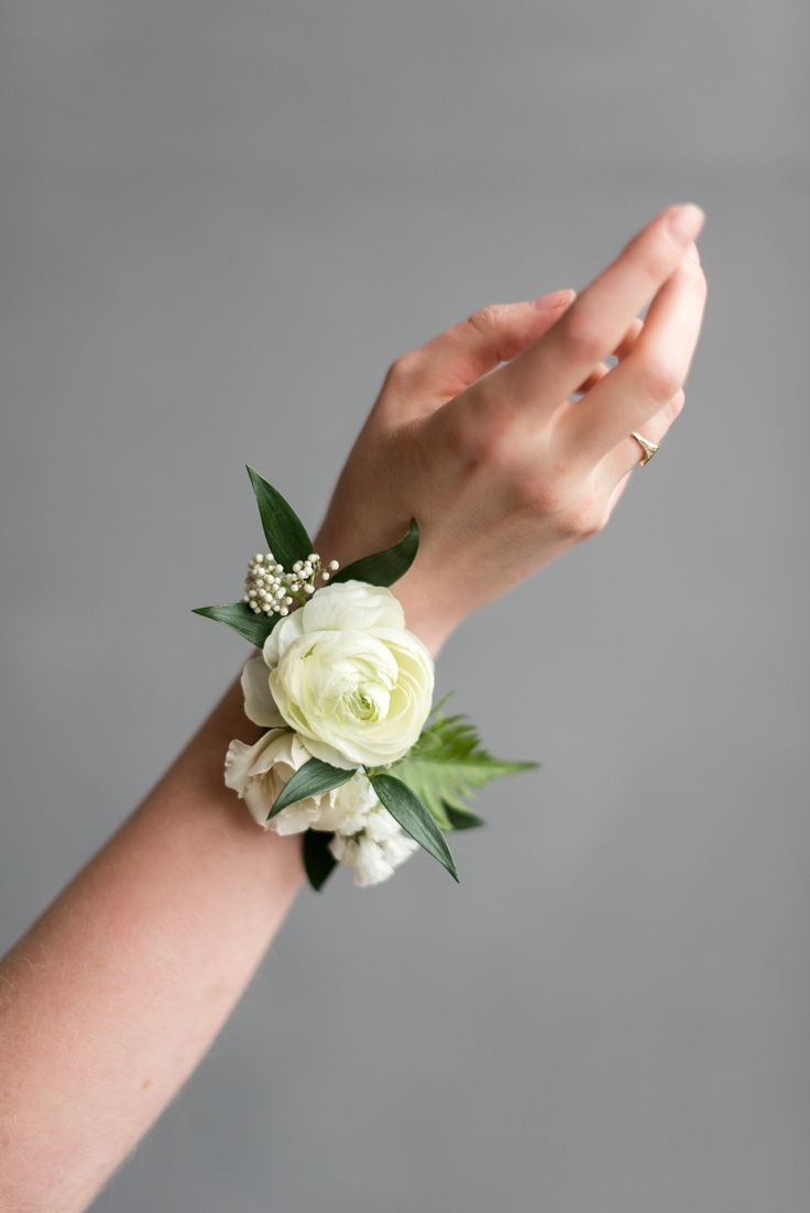 a woman's hand with a wrist corsage