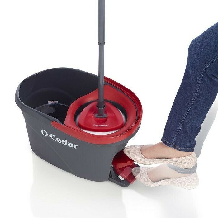 a woman standing next to a red and black bucket with a lid on it's side