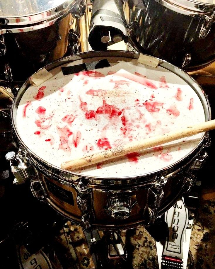 a drum with blood on it and two drums in the background