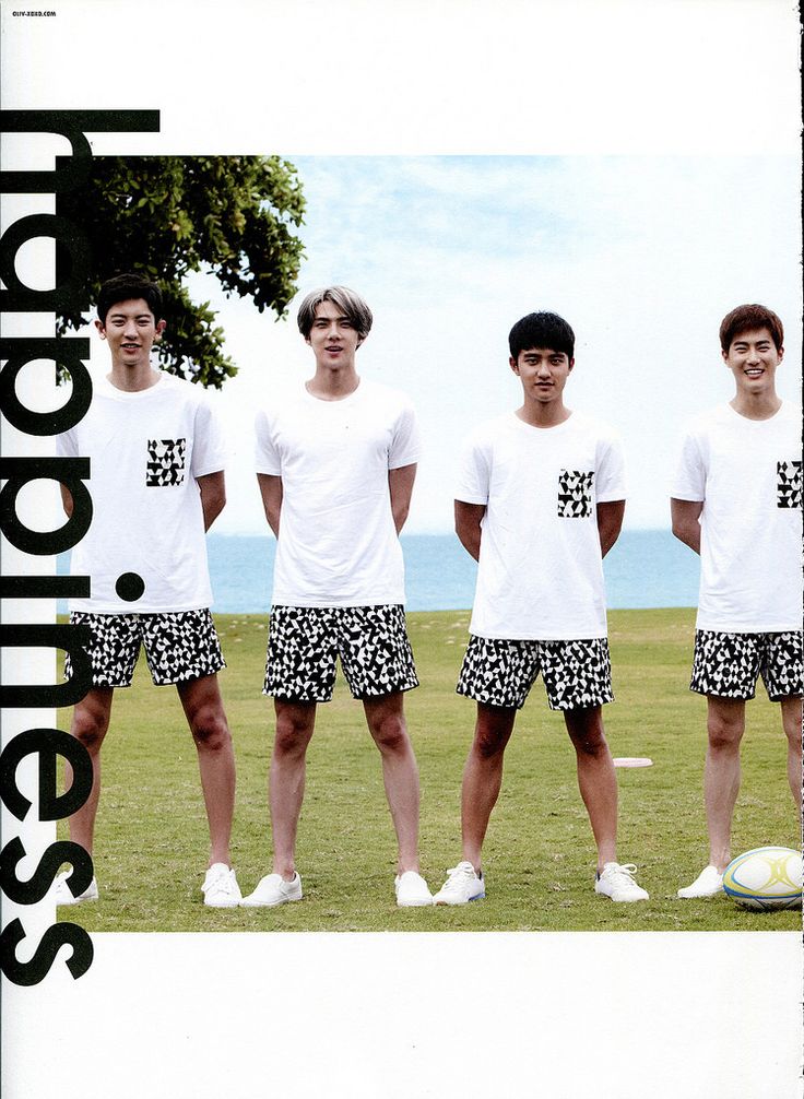 four young men standing next to each other in front of a soccer ball on a field