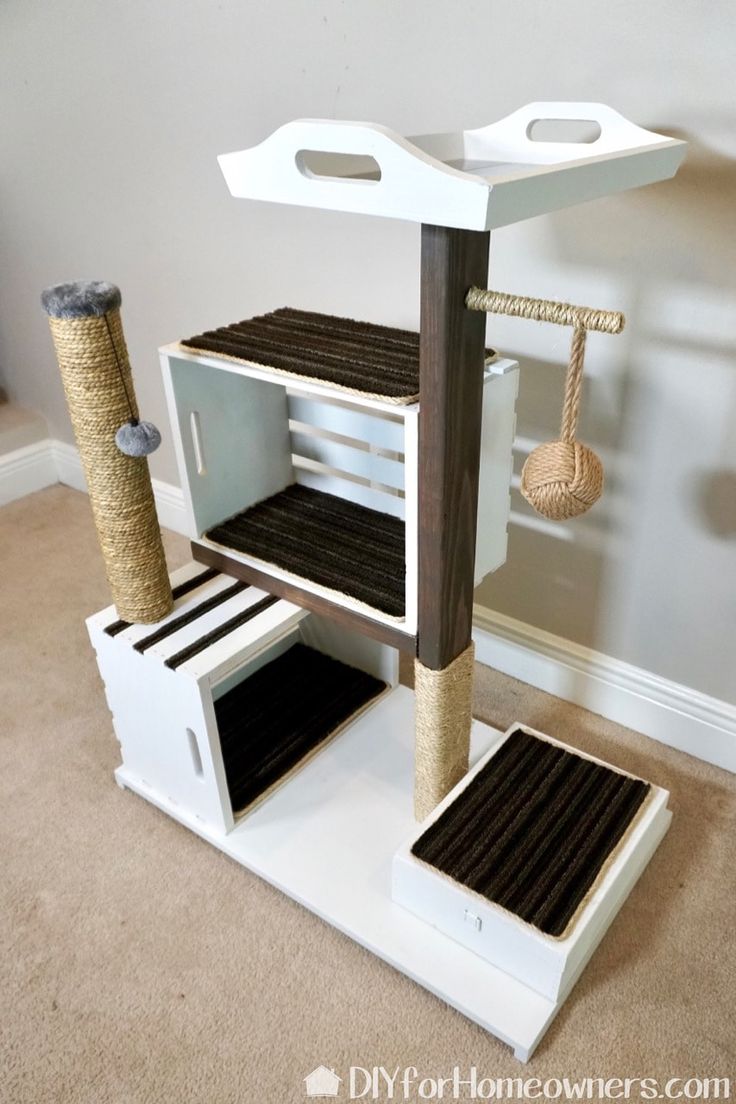 a cat house made out of pallets and other items in a room with carpeted flooring