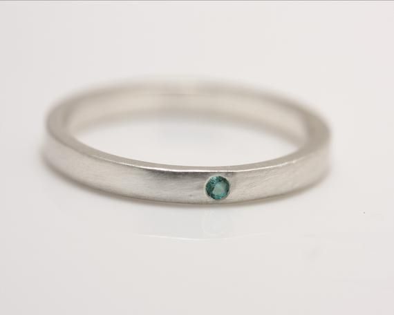 One petite 1.75 mm emerald is flush set in sterling silver in this striking minimalist ring. It can be worn by itself or as an accompaniment to another ring, as in the third photo, where it is paired with a white sapphire ring (see listing on my Etsy page).  This ring would make a beautiful engagement or wedding ring. This ring also works well as a stack ring.Please allow up to 3 weeks processing time for filling your order.Please contact me for information if you are not clear on how to measure Minimalist Stackable Emerald Cut White Gold Rings, Minimalist Stackable White Gold Emerald Cut Rings, Minimalist White Gold Stackable Rings With Emerald Cut, Minimalist Sterling Silver Birthstone Ring With Single Diamond, Sterling Silver Emerald Ring With Bezel Setting, Minimalist Emerald Cut Stackable Rings, Minimalist Birthstone Ring With Tension Setting, Everyday Minimalist Emerald Cut Ring, Everyday Minimalist Emerald Ring