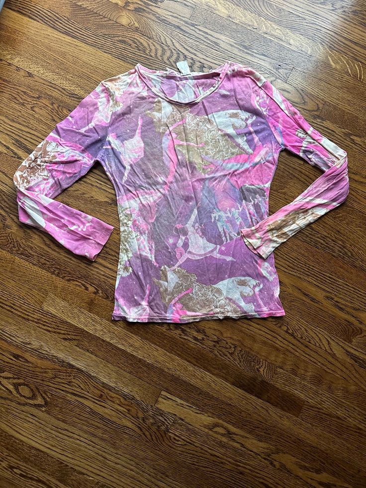 This 70's  vintage novelty shirt is long sleeve in pink purple and tan abstract splotches.  It has dancing women in the pattern. It is light weight.  It is in decent condition.  The hems are a little rolled as shown in pictures. Chest-33 inches with no pull Waist-26 inches Bottom hem-30 inches Sleeve-22.5 inches Shoulder seam to shoulder seam- 15 inches Length from shoulder to hem-22 inches To see more of our authentic 1970's clothing inventory please visit our store at ChoiceRecycling.  We add new items every week. Thank you, Karmyn Casual Long Sleeve Tops With Abstract Print, Spring Long Sleeve Graphic T-shirt, Purple Long Sleeve Top With Graphic Print, Pink Stretch T-shirt For Spring, Spring Graphic Print Stretch Blouse, Pink Graphic Print Top For Fall, Pink Stretch Crew Neck Shirt, Spring Stretch Blouse With Graphic Print, Spring Long Sleeve Shirt With Abstract Print