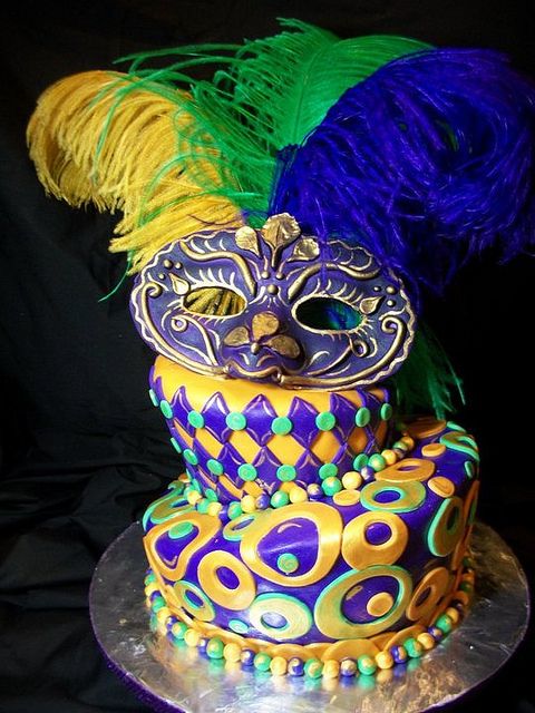 a masquerade cake decorated with feathers and beads