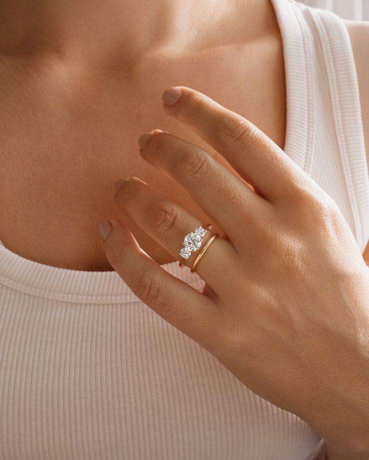 a woman wearing a ring with a diamond on it