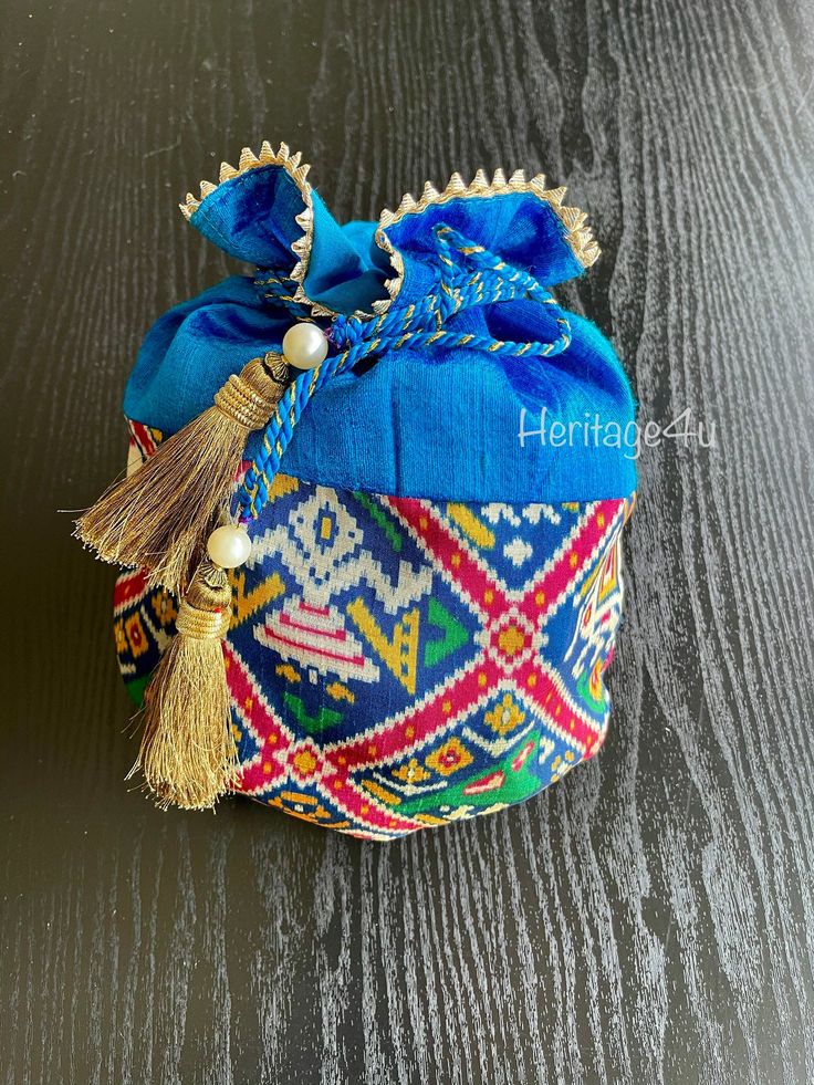 Beautiful Patola Potli bags Ditch your designer clutches for your next wedding or prewedding event and rock these festive potli bags Material: silk Handmade tassels Gold lace around the face of the potli Perfect for any occasion such as weddings, pre wedding ceremonies, bridal showers , and baby showers. Wear to any event all in all! follow us on insta and facebook for more photos @ Heritage_4u Traditional Blue Bags For Festivals, Traditional Tassel Pouch Bag, Traditional Pouch Bag With Tassels, Traditional Blue Shoulder Bag For Festivals, Festive Celebration Bags With Tassels, Bohemian Multicolor Potli Bag For Diwali, Traditional Wedding Potli Bag With Tassels, Multicolor Potli Bag For Wedding And Navratri, Bohemian Multicolor Potli Bag Pouch