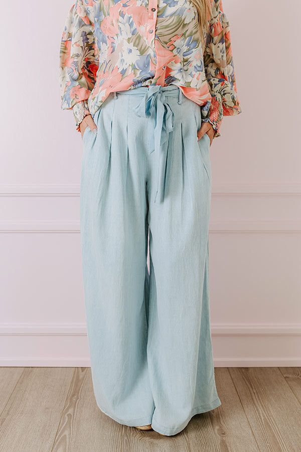 - Go with this flow in these trendy pants! - Unlined chambray material - A waistline with an elastic back, belt loops, and a removable tie closure belt - Pleated details on front - Functional side pockets - A relaxed silhouette that ends in wide floor length hemlines Spring Washed Blue Cargo Pants, Casual Belted Bottoms In Denim Blue, Chic Belted Denim Blue Bottoms, Casual Denim Blue Belted Bottoms, Linen Bottoms With Tie Waist For Work, Spring Light Wash Pants With Pockets, Medium Wash Belted Straight Leg Bottoms, Trendy Blue Belted Bottoms, Medium Wash Paperbag Waist Bottoms With Pockets