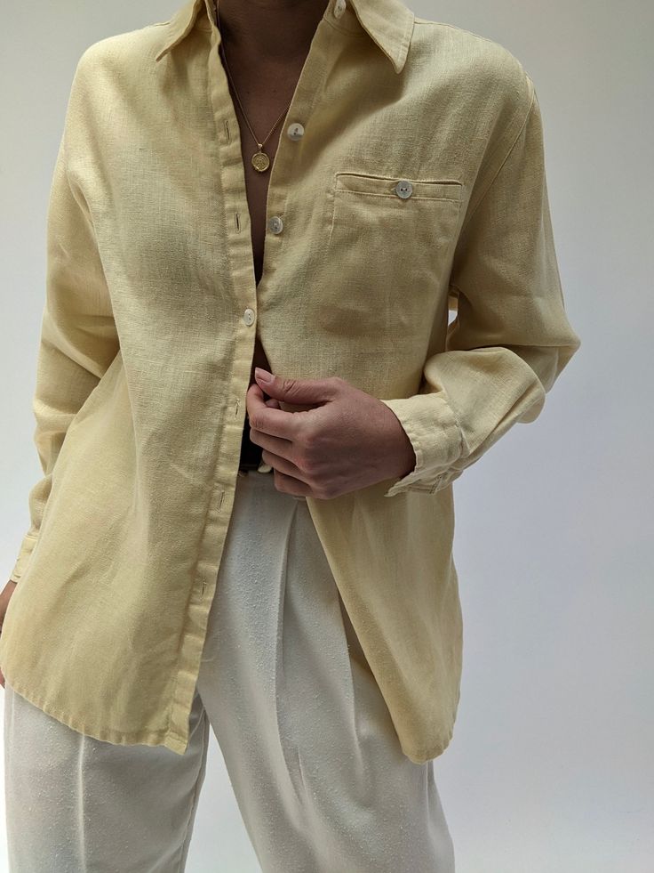 Classic summer linen blouse is a butter yellow. Blouse has button closures up the front, a collared neckline and a single pocket at the chest. Tag reads Studio Works There is a very faint spot at the center back body - not noticeable unless inspecting for flaws. Pale Yellow Clothes, Spring Flax Button-up Shirt, Yellow Summer Blouse With Pockets, Yellow Blouse With Pockets For Summer, Yellow Blouse With Pockets, Classic Tops With Buttoned Pockets For Spring, Classic Daywear Blouse With Buttoned Pockets, Classic Long Sleeve Flax Tops, Summer Collar Blouse With Pockets