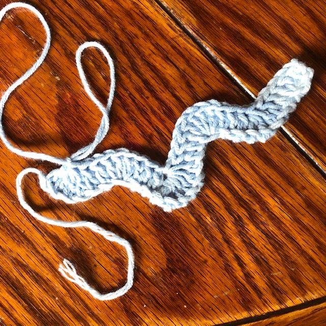 there is a crochet piece on the floor that has been made to look like a snake