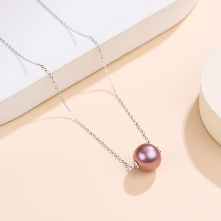 Make a statement with these beautiful classic freshwater pearl floating pendant necklaces from House of Pearls. Ranging from 9-12mm, this piece provides a luxurious combination of 4A pearls for a timeless look. With a range of colors available, you’re sure to find something special for any occasion. Hang it from your favorite silver or gold chain and watch as the light dances off each beautiful pearl. Lavender Freshwater Pearl 9-12.0mm Pearl Necklace This popular necklace design features AAAA qu High Luster Round Necklace, Elegant Pink Round Pendant Necklace, High Luster Round Beads Necklace, Elegant Pink Necklace, Pink Pearl Charm Necklace For Formal Occasions, Elegant Rose Gold Pearl Necklace With Round Beads, Formal Pink Pearl Charm Necklace, Rose Gold Pearl Necklace With Round Beads For Gift, High Luster Pearl Necklace Gift