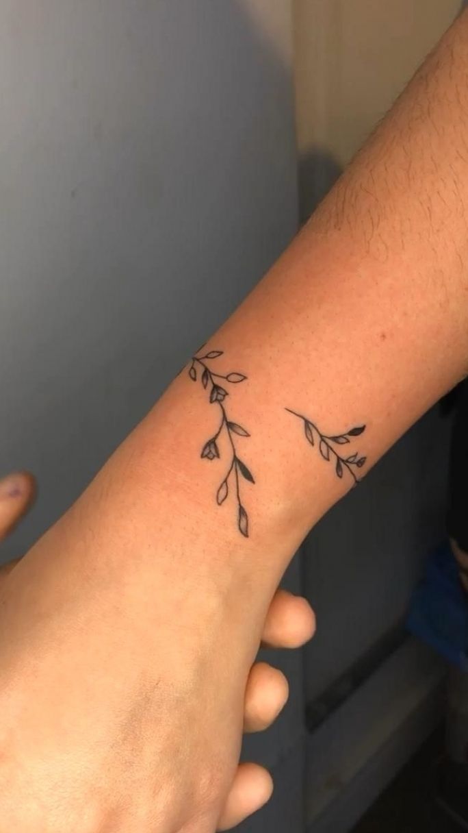 a person with a tattoo on their arm holding the hand of another person's wrist