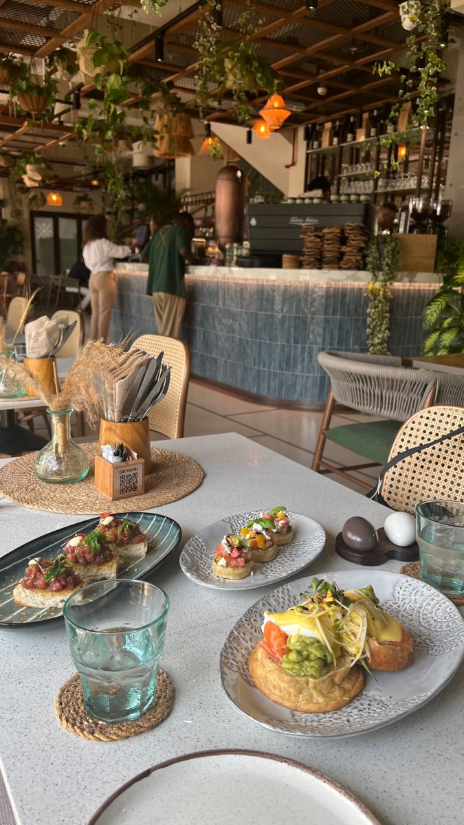 a table topped with plates of food on top of a white tablecloth covered table