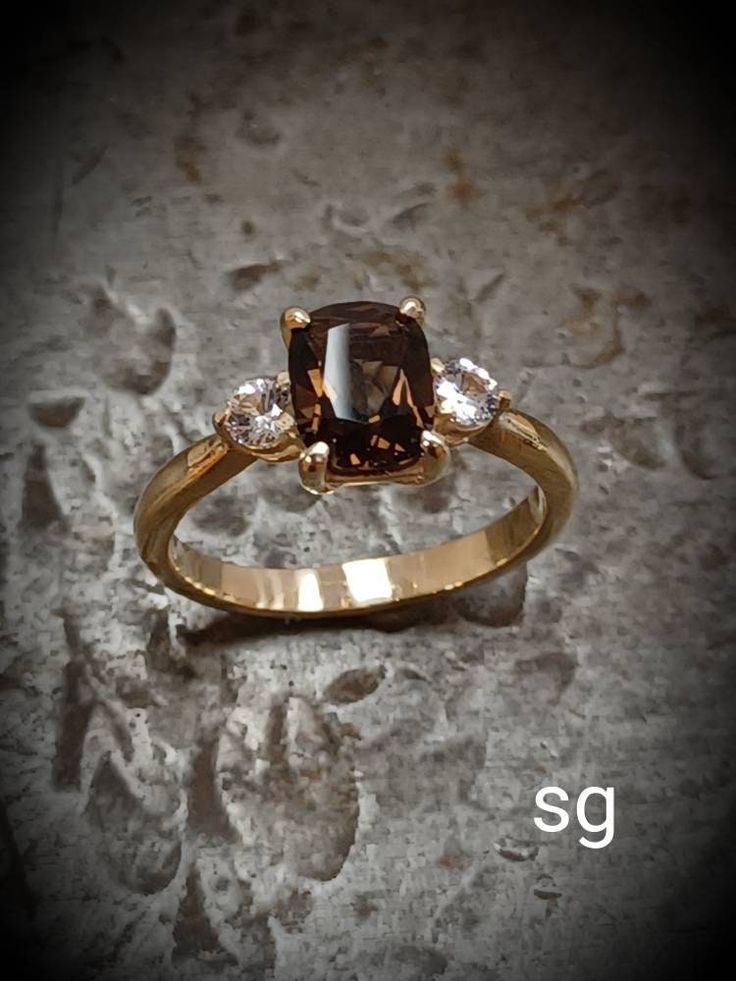 a brown diamond ring with three diamonds on it