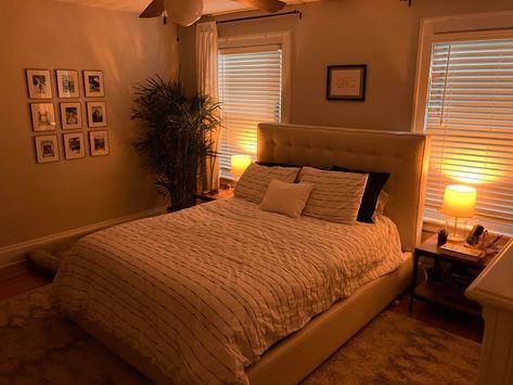 a large bed in a bedroom next to two windows with shutters on both sides