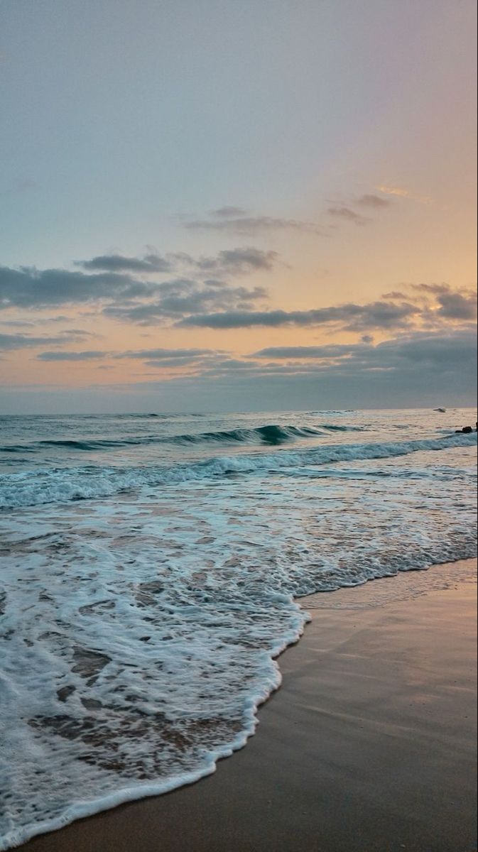 the ocean waves come in to shore at sunset