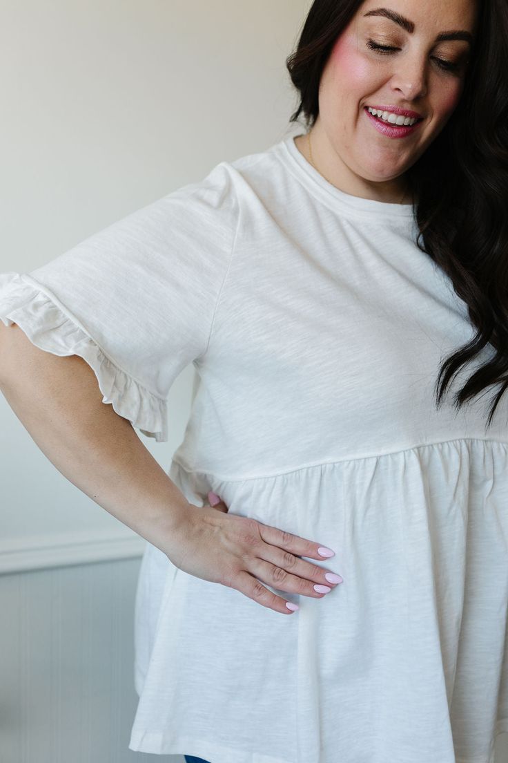 ALL SALES FINAL NOT ELIGIBLE FOR RETURN The Addie Peplum is the perfect addition to your wardrobe. With its classic white color and flattering peplum style, this top will elevate any outfit. The ruffled short sleeves and split side hems add a unique touch to this versatile piece. A must-have for a stylish and effortless look. This shirt is see through, we suggest one of our layering tanks or half tees. Fits true to size. Model is wearing a small and is 5'7". Plus model is wearing a 1X and is 5'5 Chic White Peplum Top With Ruffle Hem, Summer White Ruffle Hem Peplum Top, White Ruffle Hem Peplum Top For Summer, Summer White Peplum Top With Ruffle Hem, White Feminine Top With Ruffle Hem, White Cotton Peplum Top, Feminine White Top With Ruffle Hem, Feminine White Tops With Ruffle Hem, Everyday Ruffled Tops