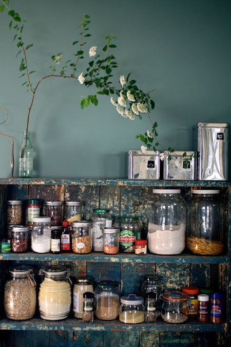 an old wooden shelf filled with jars and spices