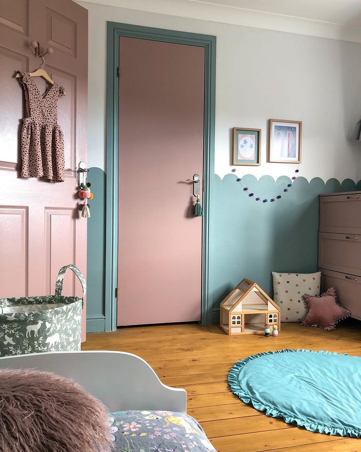 a child's bedroom with pink and blue walls, wooden flooring and furniture