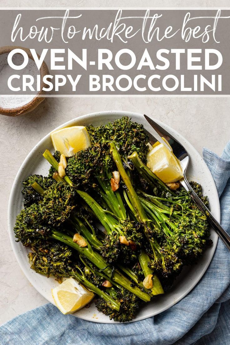 a white plate topped with broccoli and lemon wedges next to a fork