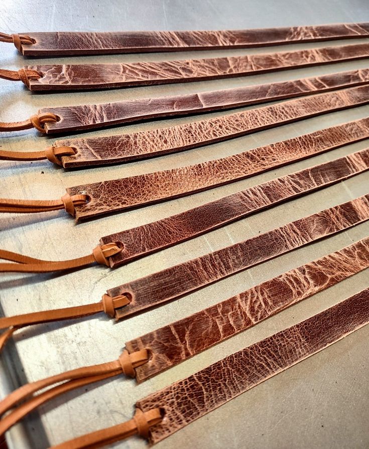 six leather straps lined up on a table