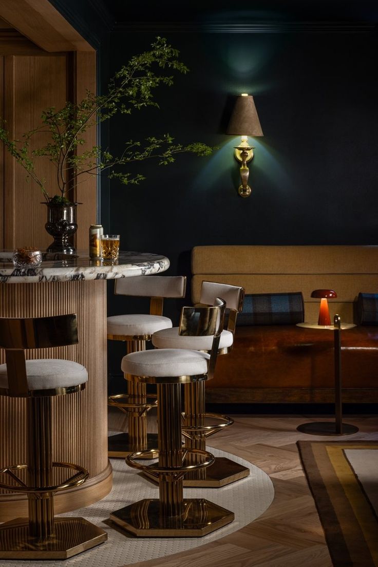 the bar is decorated with gold barstools and white stools, along with a round marble dining table