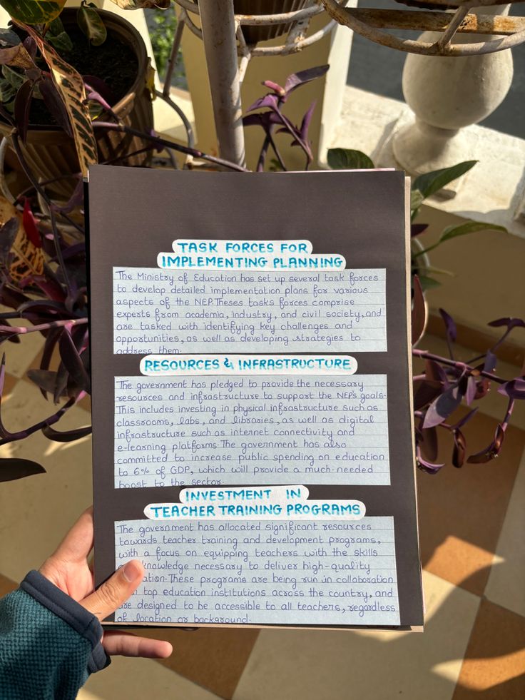 a person holding up a sign with instructions on it in front of some potted plants