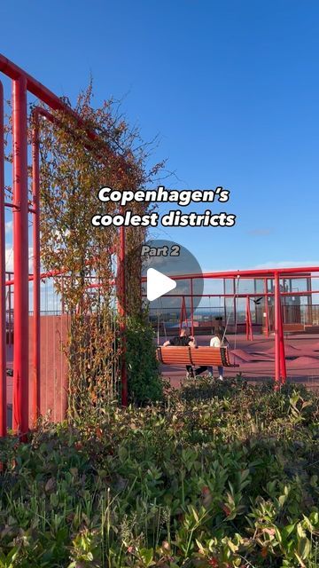 an outdoor area with red metal railings and green plants