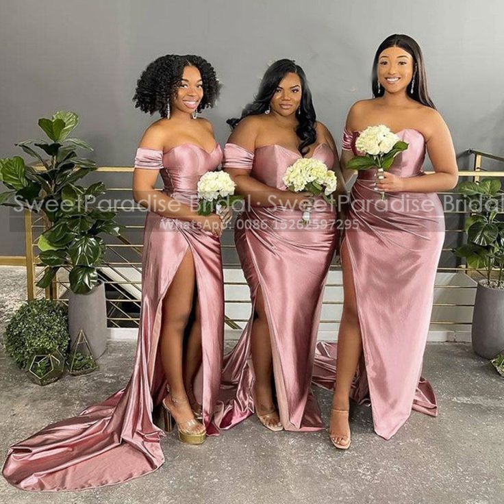 three bridesmaids in pink dresses posing for the camera with their bouquets and flowers