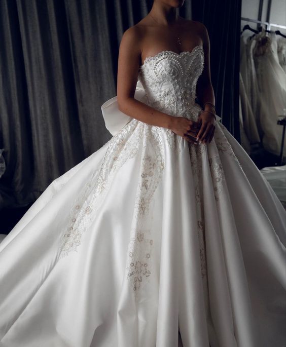 a woman in a white wedding dress is posing for the camera