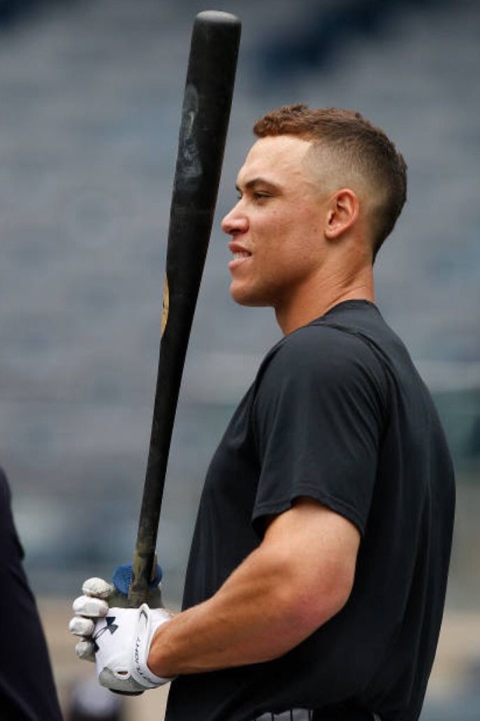 a man holding a baseball bat on top of a field