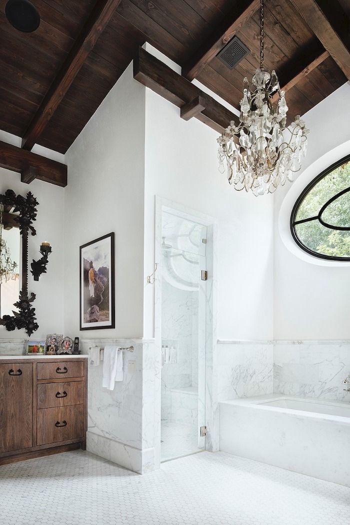 a bathroom with a chandelier hanging from the ceiling next to a bathtub