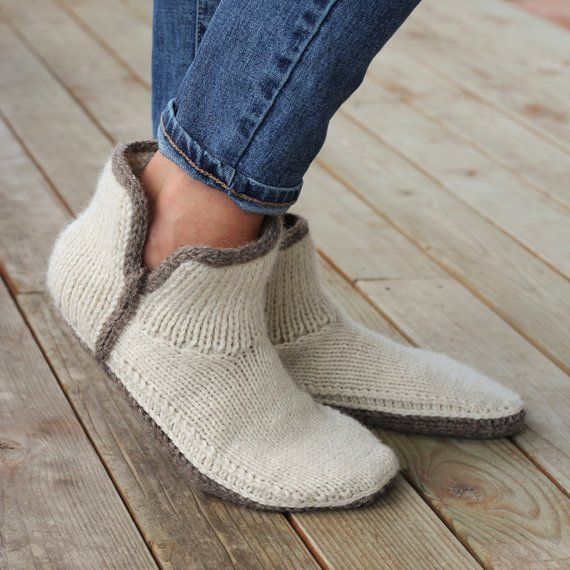 a woman's feet wearing slippers on top of a wooden floor