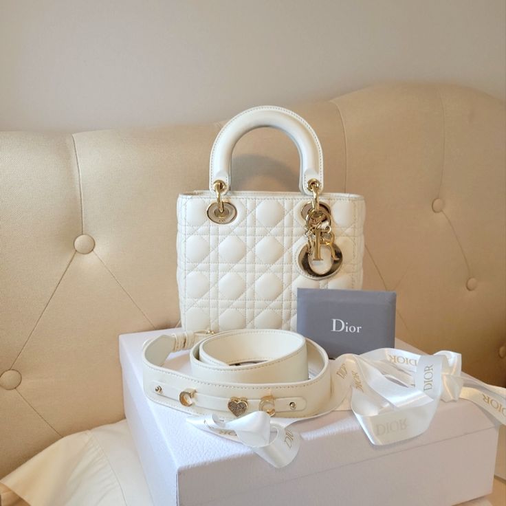 Beautiful Bag Comes With The Box, Auth Card , Strap. **Non Dior Brand Toiles Incl**** Brand: Christian Dior Style: Shoulder Bag/ Handbag/Crossbody Color: White Material: Lambskin Leather Hardware: Gold Lining: Lined Strap Style: Shoulder/Crossbody Strap Type: Bag Closure: Flap Model: Lady Dior Interior Pocket: 1 Zip Pocket & Open Pocket Country Of Origin: Italy Measurements Approximately: * Height: 6.7 In * Length: 8 In * Depth: 2.5 In **Some Light Wears On The Handles Corners And Dior Letter Hardware, Small Stain Dot Inside The Lining.( See Pics) Condition: Pre-Owned In Very Good Condition White Shoulder Bag For Evening With Original Box, Luxury Cream Shoulder Bag, White Bags With Gold-tone Hardware As A Gift, White Bags With Gold-tone Hardware For Gifts, Luxury White Bags With Pearl Handle, Luxury Beige Shoulder Bag For Wedding, Luxury Bag With Pearl Handle For Gift, Luxury Bags With Pearl Handle And Top Handle, Luxury Bags With Pearl Top Handle