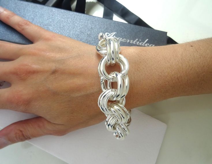 Brand: Argentidea Jewelry Instagram: https://www.instagram.com/gioielli_argentidea/ Measurement: 24cm Weight: 81g. Silver colour 925 silver bracelet, ''Garibaldi'' hollow link chain, artisanal jewel produced entirely by hand. The ''Garibaldi'' shirt was a very popular shirt in the seventies/eighties, we propose it again in 925 silver, in a maxi-sized version (81 grams). It is a very large and eye-catching bracelet with a vintage style. The bracelet has an external diameter of 20mm. The bracelet 925 Silver Bracelet Oversized, Antique Silver Hallmarked Metal Bracelets, Ornate Silver Adjustable Cuff Bracelet, Chainmail Metal Bracelet, Logo Jewelry, Handcrafted Silver Jewelry, Popular Shirt, Jewelry Instagram, 925 Silver Bracelet