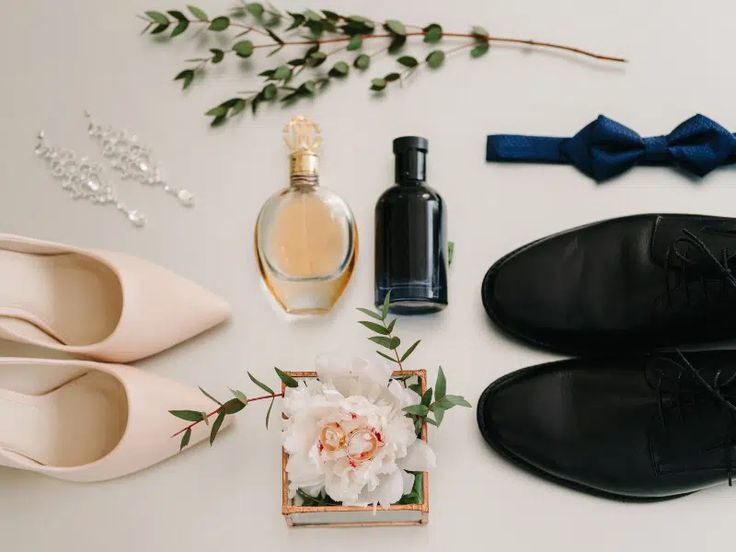 shoes, perfume and flowers are laid out on a table