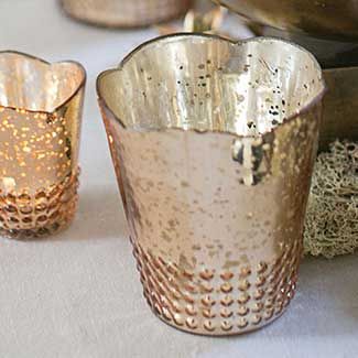 three silver cups sitting on top of a table next to each other with candles in them