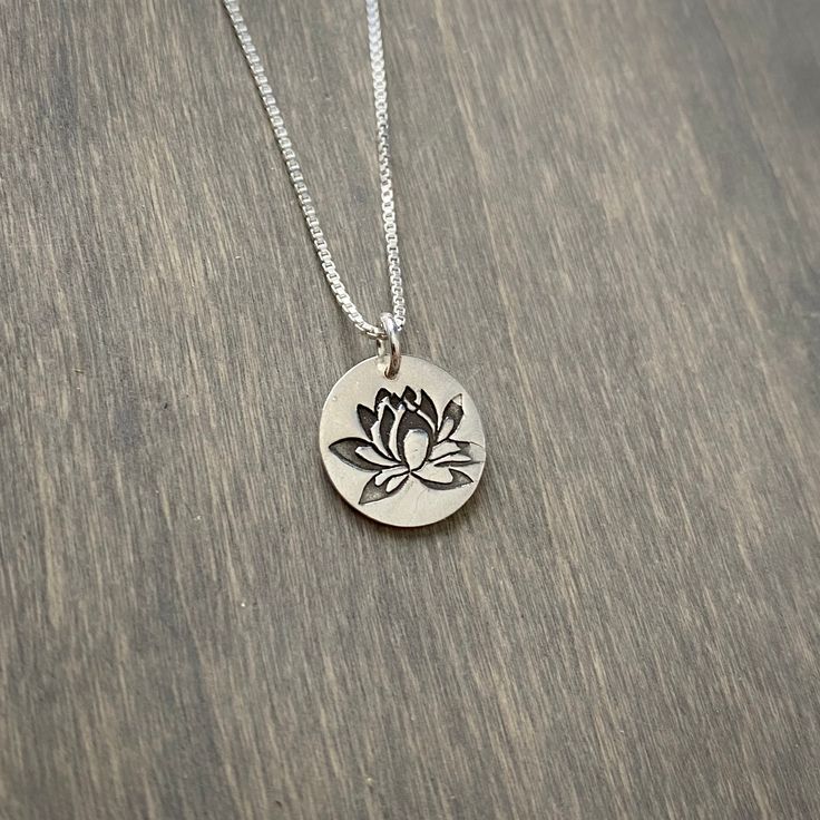 A small, stamped lotus flower pendant with an 18 inch sterling silver box chain. The pendant measures about 5/8 inch diameter. Silver Sterling Flower Necklace For Mom, Sterling Silver Pendant Flower Necklace Nickel Free, Silver Sterling Silver Flower Necklace, Silver Flower Charm Necklace For Everyday, Nickel Free Sterling Silver Flower Pendant Necklace, Sterling Silver Jewelry With Flower Charm, Everyday Silver Charm Necklace With Flower, Silver Sterling Silver Round Flower Necklace, Sterling Silver Flower Pendant Charm Necklace For Mom